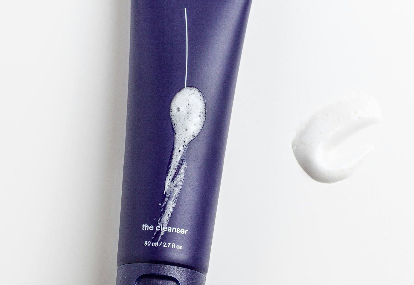 Purple tube labelled the cleanser with a smear of white foam beside it